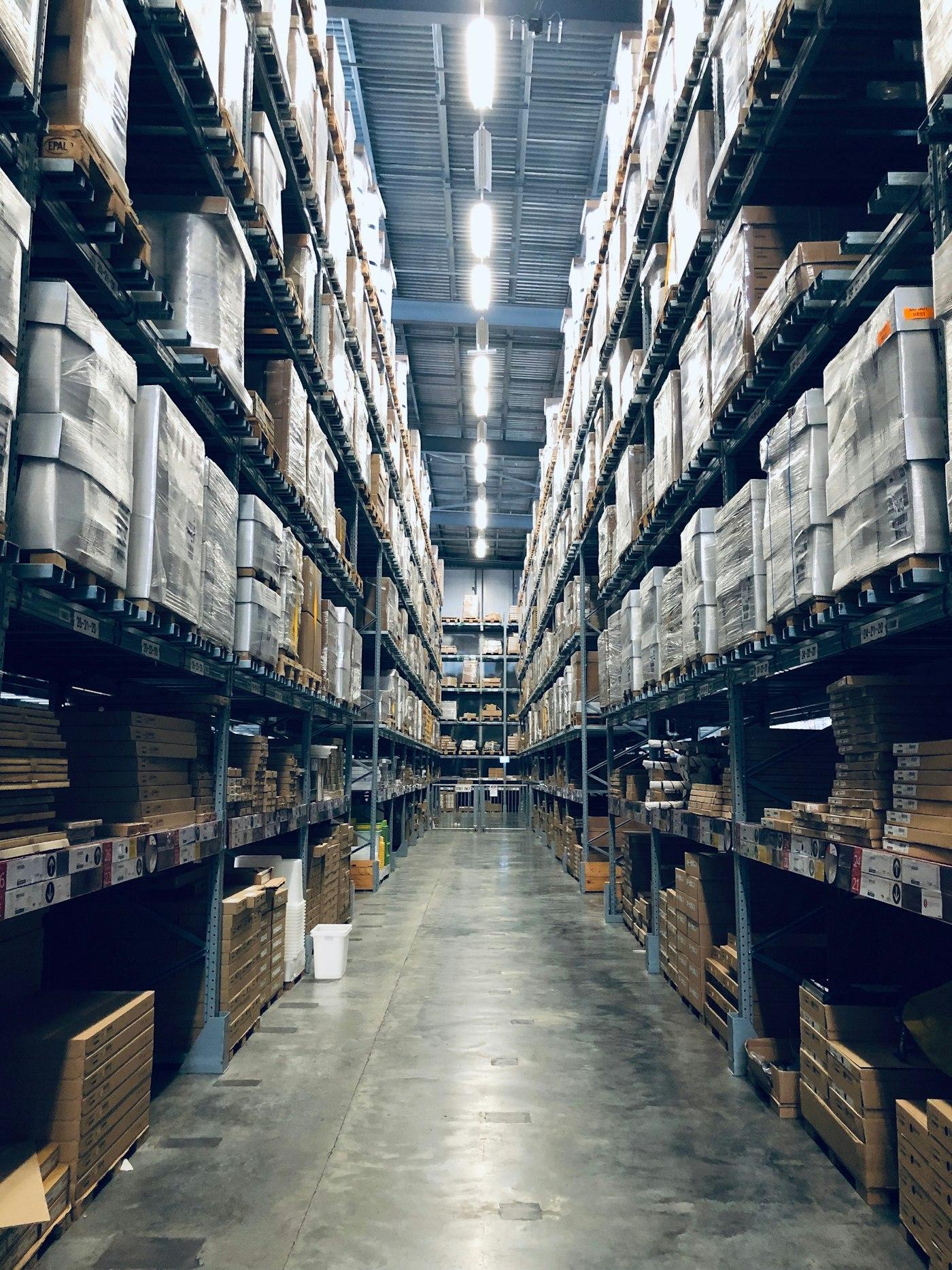 Tall warehouse aisles stacked with palletised goods